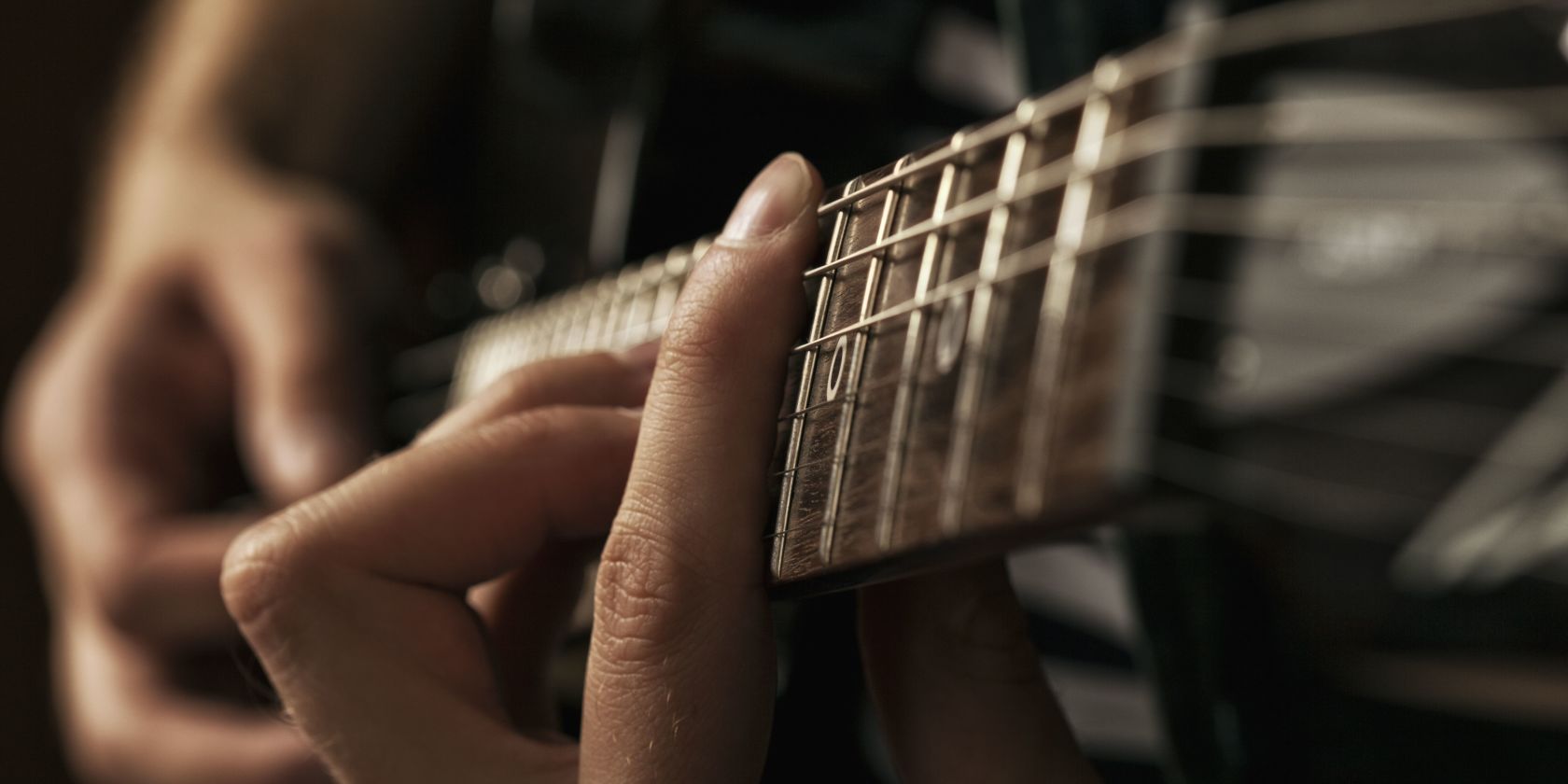 A Hand Holding A Guitar