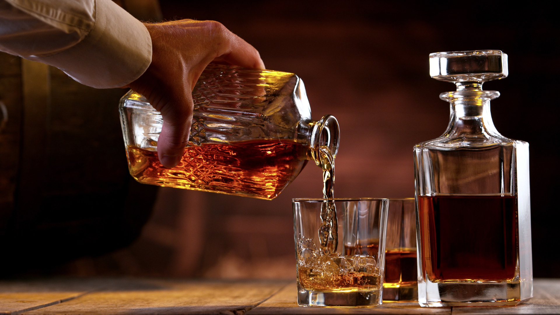 A Person Pouring Liquid Into Glasses